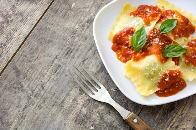 Ravioli con salsa al pomodoro e basilico su di legno