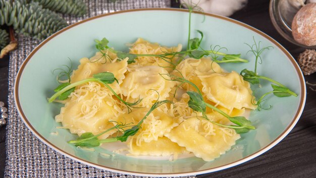 Ravioli italiani con formaggio e pianta sul piatto blu.