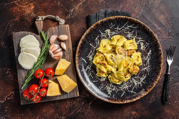 Ravioli Vegetariani Pasta con Mozzarella, Parmigiano Reggiano e Pomodoro. Sfondo scuro. Vista dall'alto.