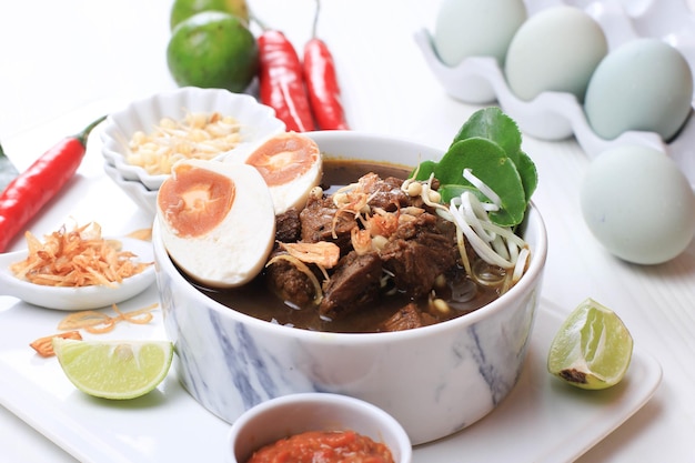 Rawon, zuppa tradizionale indonesiana di Beff Black di East Java. Servito su una ciotola con cracker di gamberetti (kerupuk Udang) e pasta di peperoncino e uovo salato