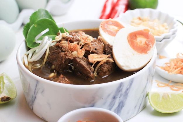 Rawon, zuppa tradizionale indonesiana di Beff Black di East Java. Servito su una ciotola con cracker di gamberetti (kerupuk Udang) e pasta di peperoncino e uovo salato