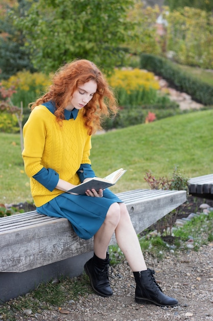 Readhead ragazza seduta in un parco