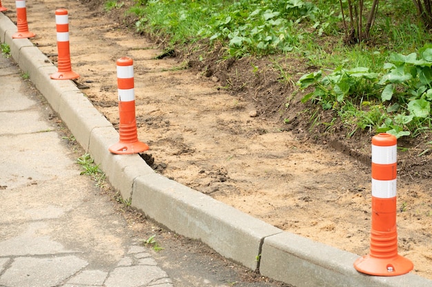 Realizzazione di un marciapiede Posa di lastre di granito su terreno sabbioso e sostituzione di portelli fognari Miglioramento delle aree urbane e rinnovamento delle infrastrutture