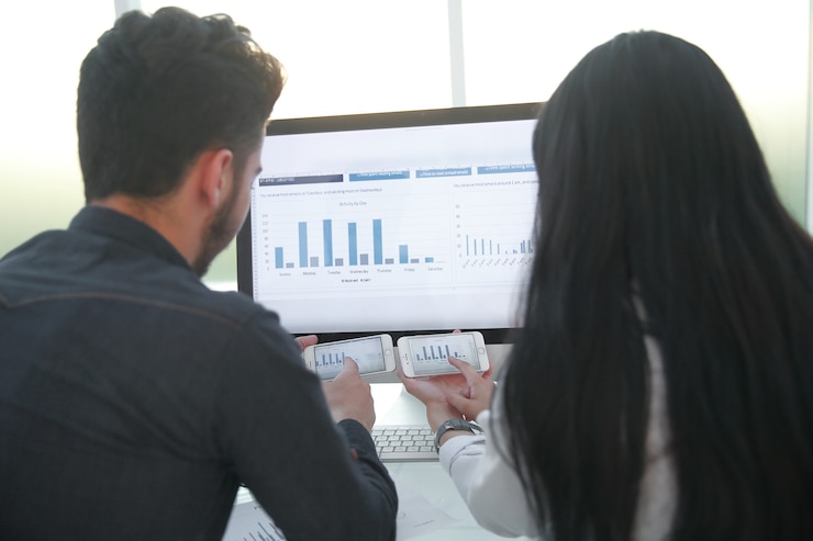 Photo rear view.businessman and businesswoman discussing financial data.people and technology