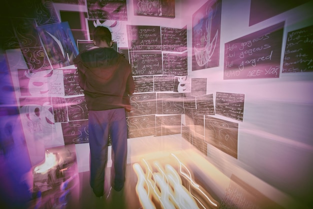 rear view shot of unknown man with mental disorder standing alone at night feeling paranoid mixed race man mentally ill feeling depressed and arranging pictures in bedroom ocd male out of control