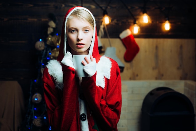 Reazioni emotive della notte della vigilia d'inverno. Ragazza sensuale per Natale. Donna di inverno che porta il cappello rosso del Babbo Natale. Holly jolly swag Christmas e noel. Abiti di Natale.