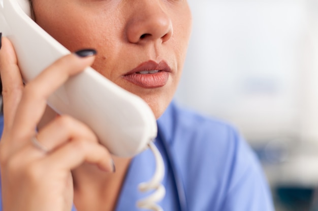 Receptionist medico che risponde alle telefonate del paziente in ospedale