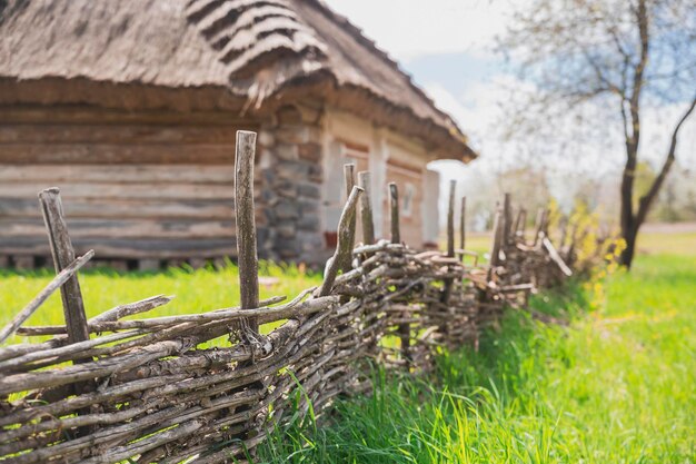 recinto di vimini vicino a una vecchia casa ucraina tradizionale