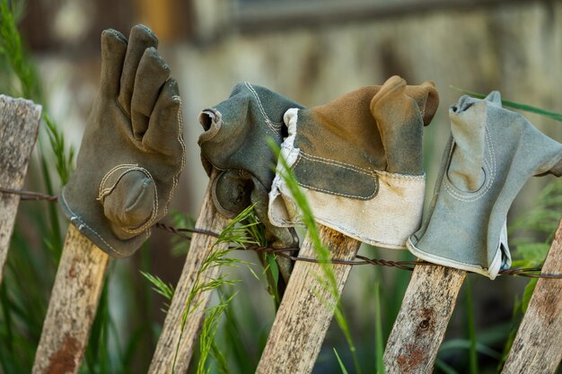 Recinzione decorata con vecchi guanti da lavoro.