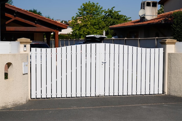 Recinzione del cancello del metallo del PVC bianco del portale sulla via moderna della casa del sobborgo