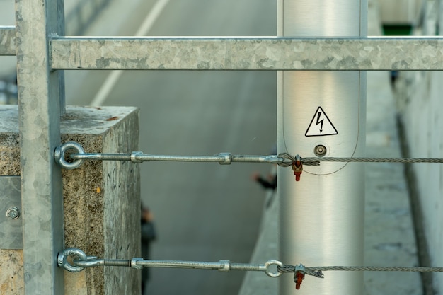 Recinzione metallica moderna realizzata con profili e cavi metallici Collegamento e fissaggio di cavi di ferro con tenditori in acciaio Fissaggio in metallo di due funi d'acciaio Recinzione attorno al perimetro del tetto