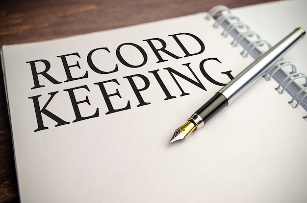 RECORD KEEPING parole su blocco note bianco e penna