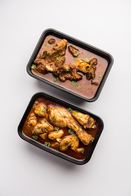 Red Chicken Curry e Montone Masala confezionati in un contenitore di plastica per la consegna