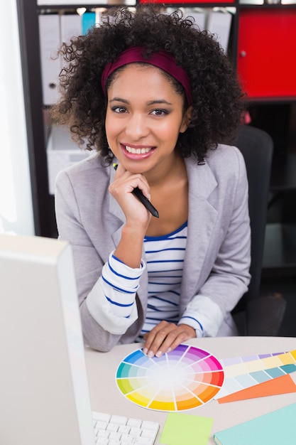 Redattore di foto femminile sorridente alla scrivania