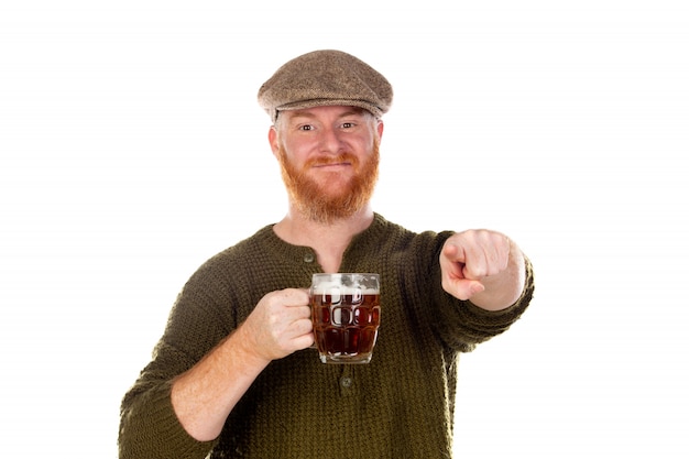 Redhead uomo con la barba lunga a bere una birra