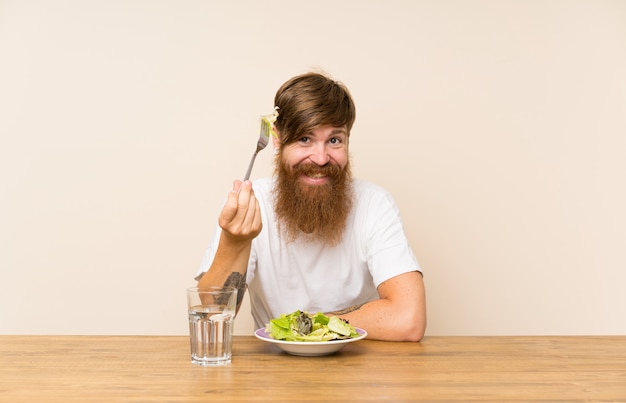 Redhead uomo con la barba lunga e con insalata