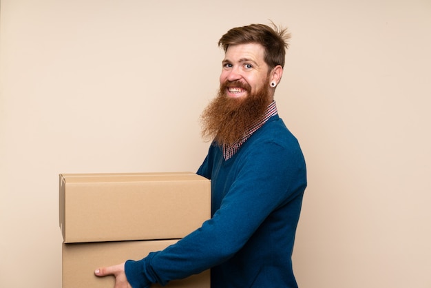 Redhead uomo con la barba lunga in possesso di una scatola per spostarlo in un altro sito