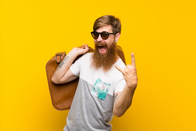 Redhead uomo con la barba lunga in possesso di una valigetta vintage