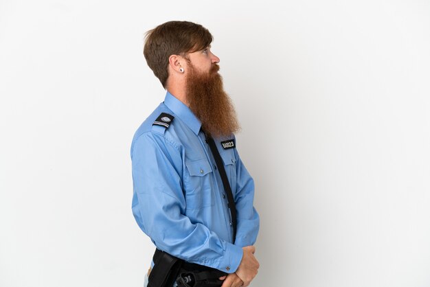 Redhead uomo di polizia isolato su sfondo bianco in posizione laterale