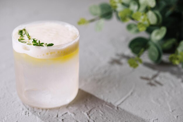 Refrescante cocktail al limone con guarnizione di timo