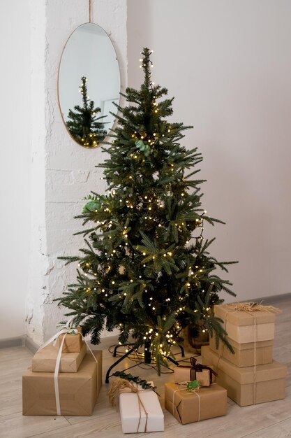 Regali artigianali sotto l'albero Il concetto di Natale e CapodannoUmore natalizio Celebrazione del nuovo annoMolte scatole di regali di Natale in eco-stile di imballaggio di carta artigianale ecofriendly