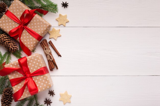 Regali di Capodanno con biscotti e cannella su fondo di legno bianco, vista dall'alto, spazio di copia