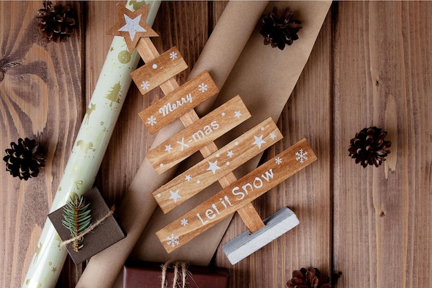 Regali di Natale avvolti in carta artigianale su tavola di legno Processo di confezionamento dei regali Sfondo stile di vita Vista dall'alto Concetto di Natale