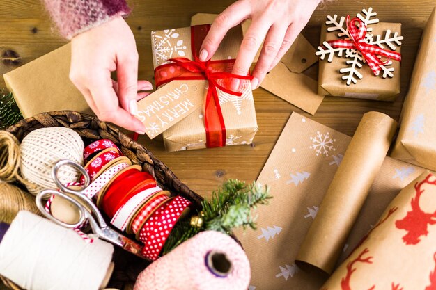 Regali di Natale avvolti in carta marrone con nastri rossi.