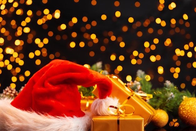 Regali di Natale avvolti sulla fine dorata del fondo del bokeh delle luci su