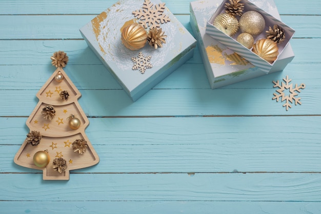 Regali di Natale con decorazioni dorate su fondo di legno blu