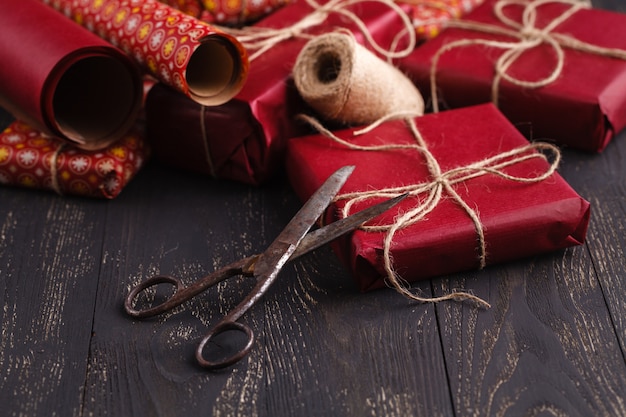 Regali di Natale creativamente avvolti e decorati in scatole su superficie di legno