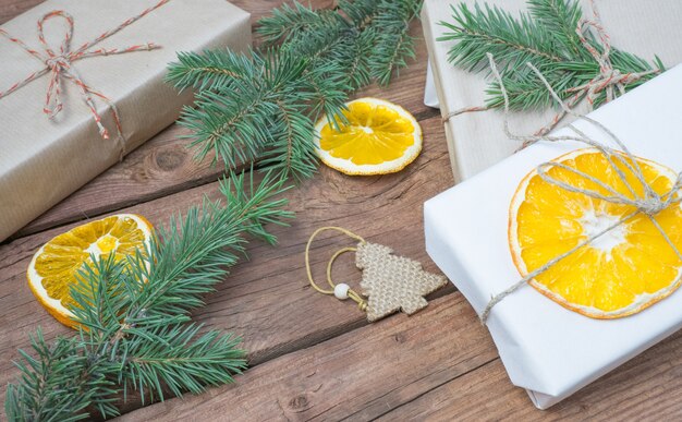Regali di Natale o scatola regalo avvolta in carta kraft con decorazioni pigne arancio secco
