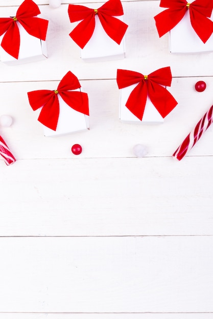 Regali di Natale, scatoline bianche con fiocco rosso e caramelle.