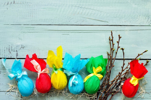 Regalo decorativo uovo di Pasqua fatto a mano legato con nastri su un tavolo di legno