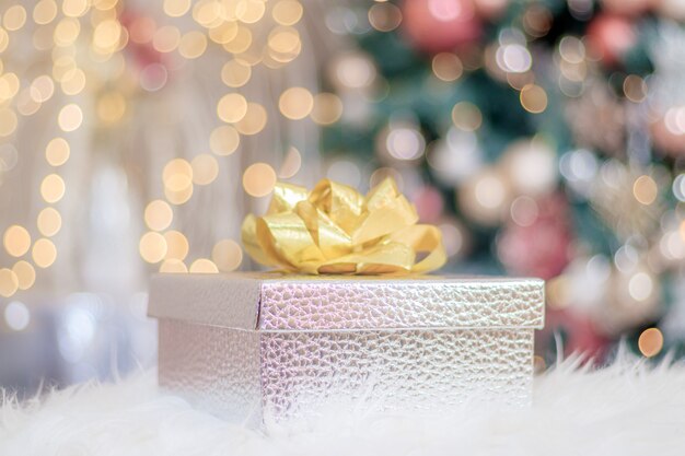 Regalo di Capodanno sullo sfondo di un albero di Natale. Capodanno e Natale. Regali per le vacanze. Atmosfera festosa. Un albero di Natale. Bokeh.