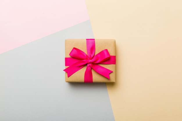 Regalo di carta per le vacanze con fiocco rosa legato vista dall'alto con spazio per la copia Sfondo vacanza piatto per compleanno Regalo di Natale o di compleanno Concetto di confezione regalo di Natale con spazio per la copia