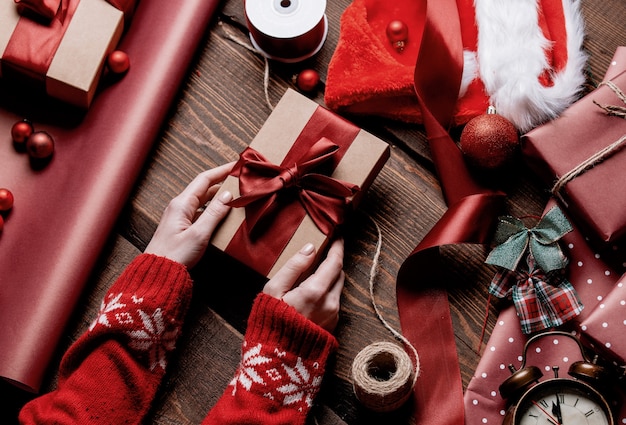 Regalo di incarto della donna sulla tavola di legno