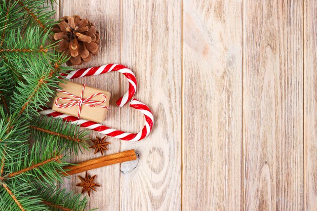 Regalo di Natale, bastoncini di zucchero e fiocchi di neve su un fondo di legno