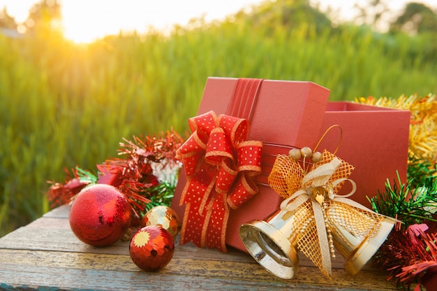 Regalo di Natale con decorazioni sul tavolo di legno nel tramonto