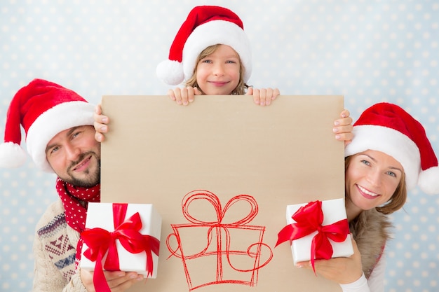 Regalo di Natale della tenuta della famiglia e spazio in bianco dell'insegna. Concetto di vacanza di Natale