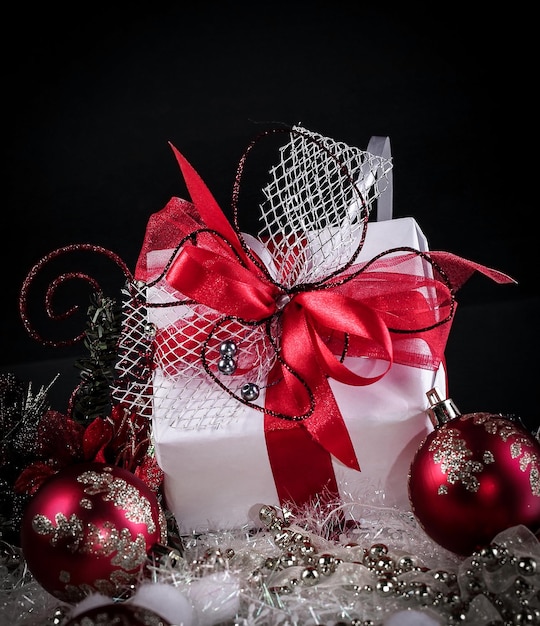 Regalo di Natale e palle di Natale rosse su sfondo nero