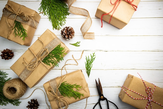 Regalo di Natale o scatola regalo avvolta in carta kraft con decorazione su fondo in legno rustico