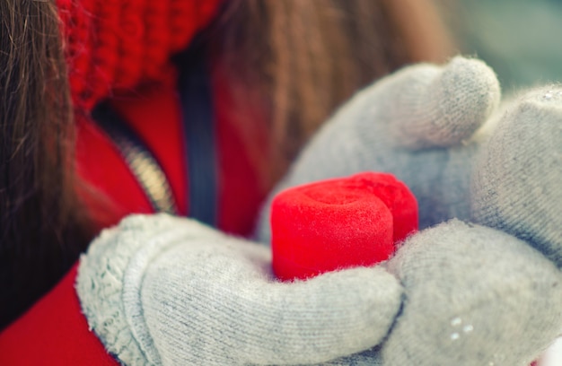 Regalo di San Valentino in una scatola rossa a forma di cuore in guanti.