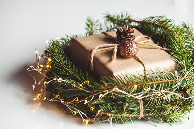 Regalo in carta artigianale in una ghirlanda di alberi di Natale. Atmosfera natalizia, Capodanno, su sfondo bianco