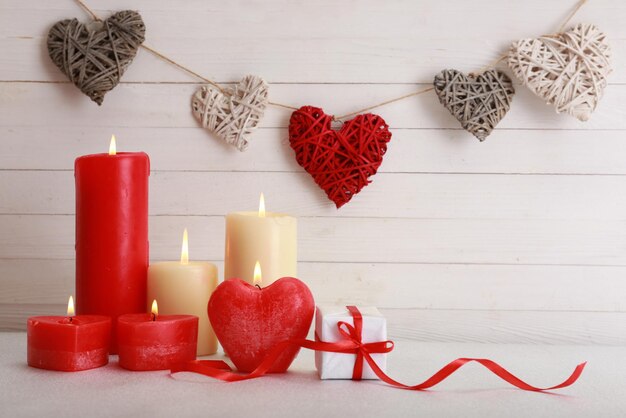 Regalo romantico con candele su fondo di legno. concetto di amore