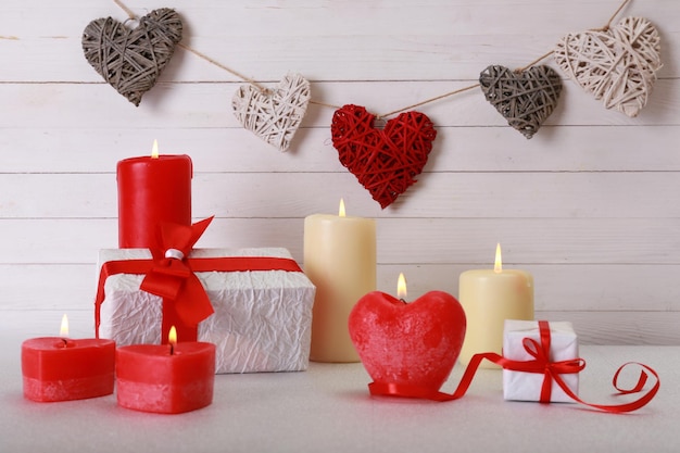 Regalo romantico con candele su fondo di legno. Concetto di amore