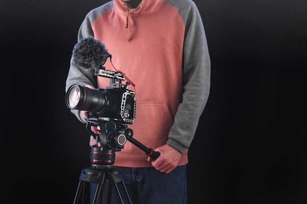 Regista o direttore della fotografia che utilizza attrezzatura fotografica professionale per realizzare documentari e film. Concetti di giovane cameraman, audiovisivo, narrazione e regia di film.