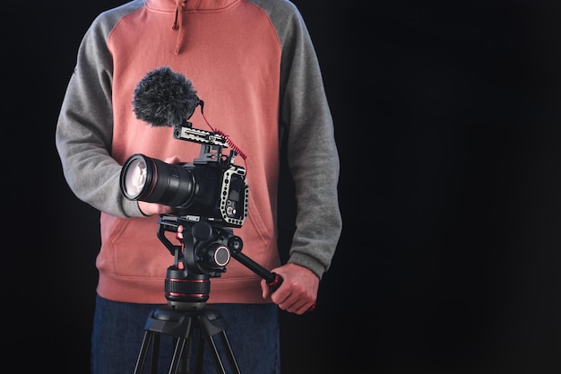 Regista o direttore della fotografia che utilizza attrezzatura fotografica professionale per realizzare documentari e film. Concetti di giovane cameraman, audiovisivo, narrazione e regia di film.