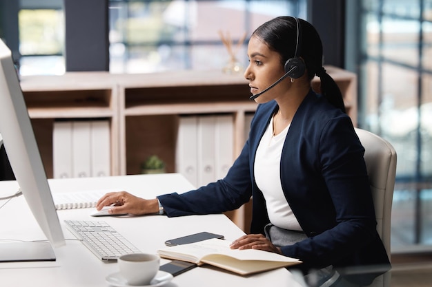 Registrazione di alcune questioni per un'ulteriore ispezione Inquadratura di una giovane donna d'affari che lavora su un computer in un call center