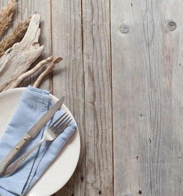 Regolazione della tabella con tovagliolo blu e legno vecchio